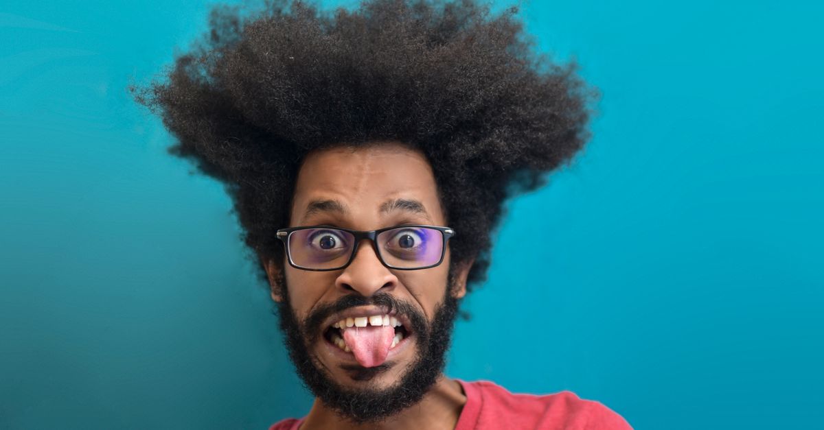 A humorous portrait of a man with an afro making a silly face against a turquoise background.